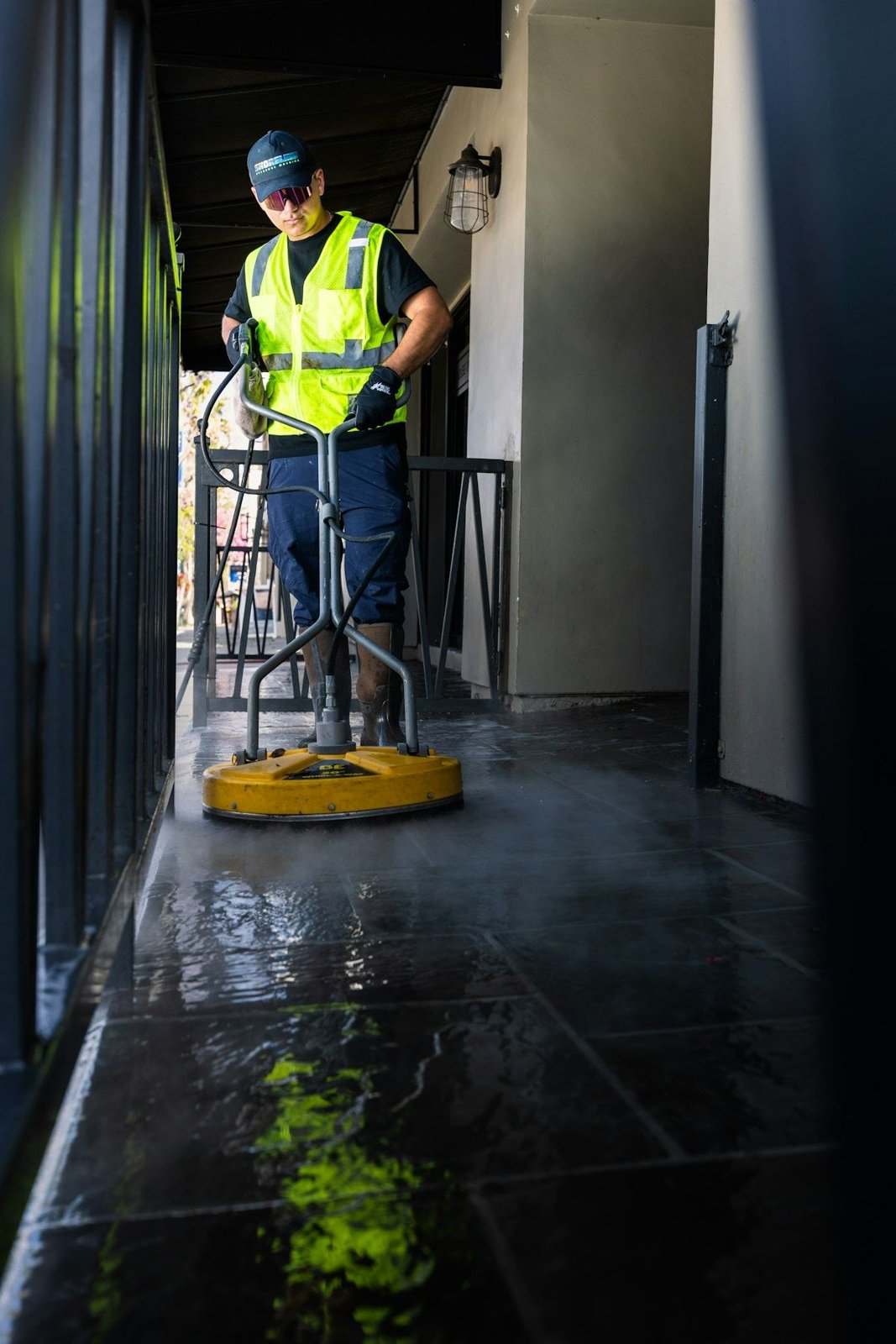 Technician cleaning a walkway with a surface cleaner